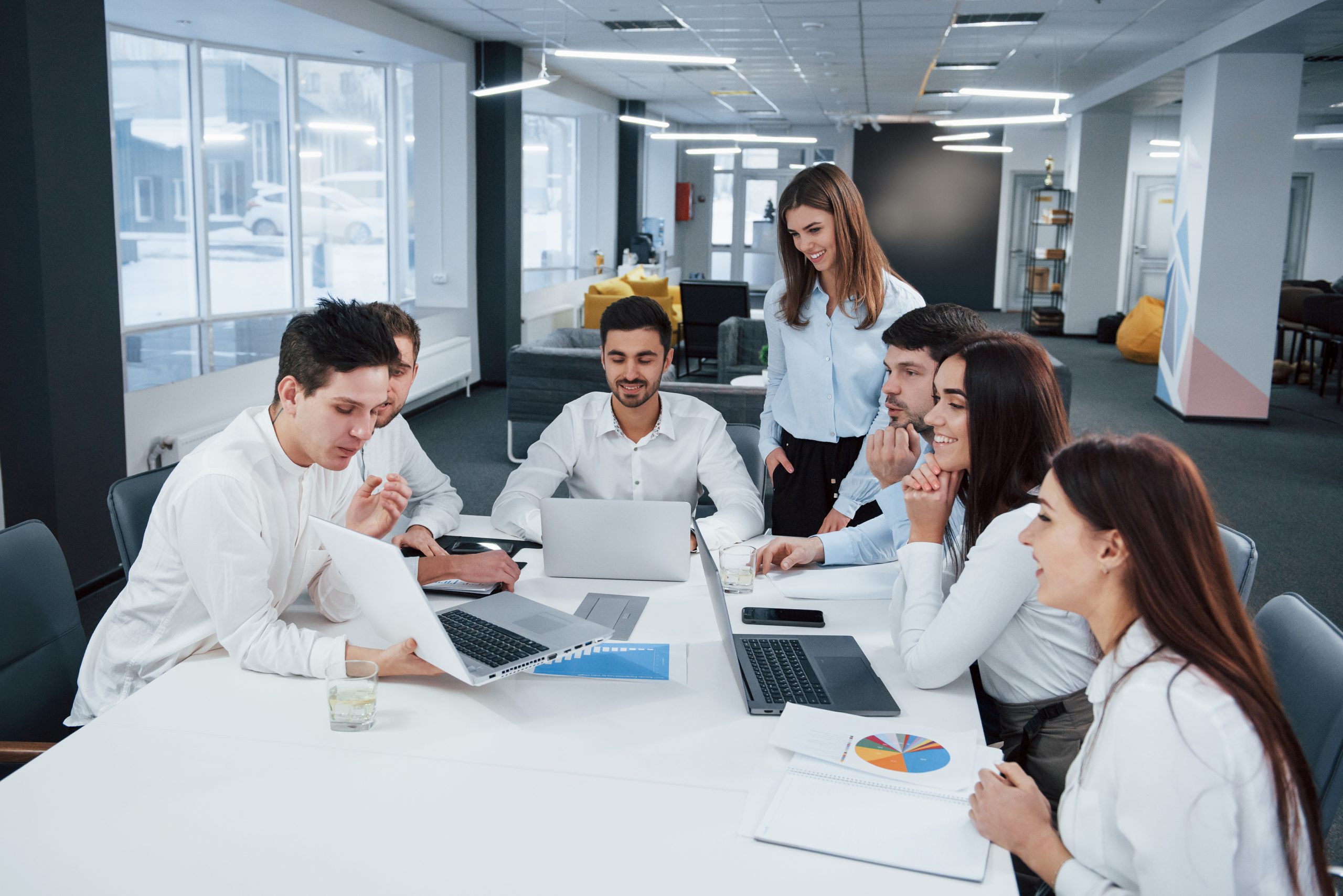 Showing good results. Group of young freelancers in the office have conversation and smiling Showing good results. Group of young freelancers in the office have conversation and smiling.